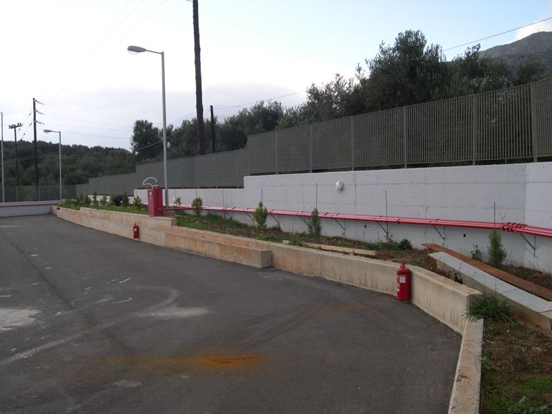 Εξωτερικό πυροσβεστικό δίκτυο και πυροσβεστήρες σε ράμπα, λόφοι στο βάθος